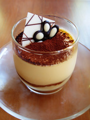 Tiramisu in a glass cup on table
