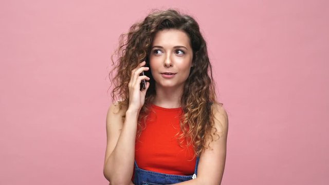 Young happy caucasian woman talking with friends isolated over pink background