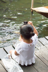 魚にエサをやる幼女