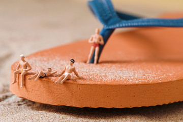 miniature people in swimsuit on the beach