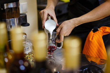 Barista pours milk for making macchiato or latte coffee