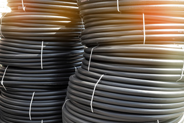 Spiral black plastic pipes, stored in the open air. Background