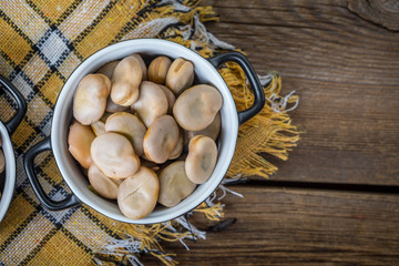 Broad beans served in black bowls.