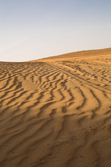 Naklejka premium A huge blue summer sky sky, over a beautiful golden desert sand dune. Sand textures.
