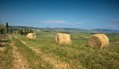 Beautiful landscape with twisted haystack in a field  in Toscana, Italy