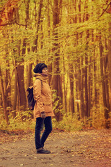 Fototapeta premium Young stylish hipster girl standing in the autumn park and smiling