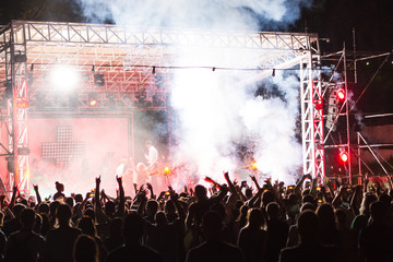 Rear view of crowd with arms outstretched at concert. cheering crowd at rock concert. silhouettes...