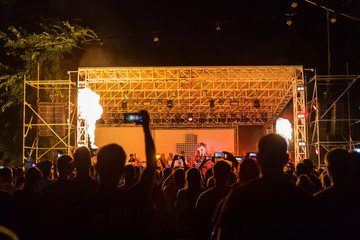 Hand with smartphone records live music festival, taking photo of concert stage live concert luxury...