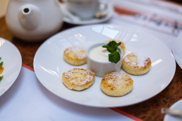 Pancakes in dish on Table wood with sour cream