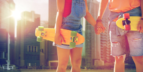 close up of young couple with skateboards in city