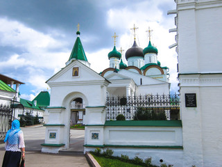 A woman in a scarf at the entrance of the church Pechersky Ascension Monastery,  Nizhny Novgorod,...