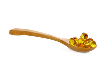 Fish oil pill in wooden spoon isolated on whiteFish oil pill in wooden spoon isolated on white background