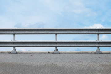 railing at road side on blue sky background