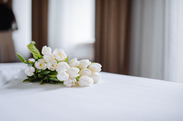 Bouquet of tulips on white bed