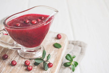 Fresh Lingonberry sauce in a gravy boat closeup, copy space