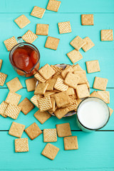 tasty breakfast crackers with jam and milk on a wooden surface, top view. Space for text