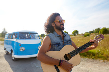 hippie man playing guitar at minivan car outdoor