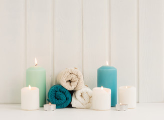 Obraz na płótnie Canvas Spa composition. Spa candles. turquoise towels on rustic white wooden background.