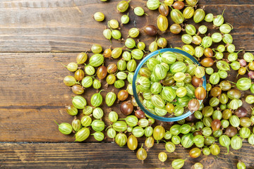 Gooseberries in a plate on a wooden background