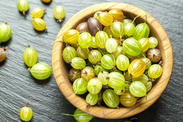 Ripe gooseberry in a wooden plate