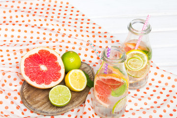 Infused flavored water with fresh fruits on white wooden background.Refreshing summer homemade  detox water
