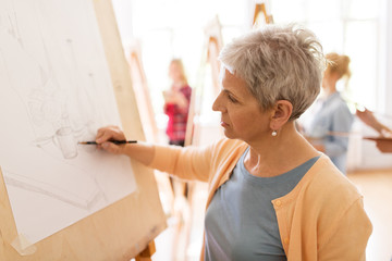 woman artist with pencil drawing at art school