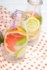 Infused flavored water with fresh fruits on white wooden background.Refreshing summer homemade  detox water