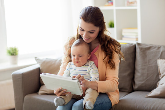 Happy Mother With Baby And Tablet Pc At Home