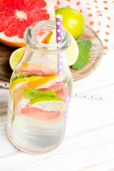 Infused flavored water with fresh fruits on white wooden background.Refreshing summer homemade  detox water