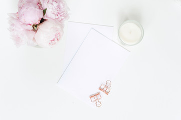 Wedding card with pink peoniesand candle. Flat lay.