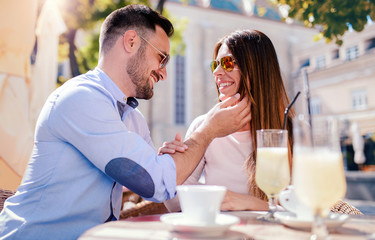 Romantic couple drinking coffee and lemonade, having a date in the cafe. Dating, love, relationships