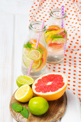 Infused flavored water with fresh fruits on white wooden background.Refreshing summer homemade  detox water