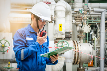 asian technician working with the walkie-talkie and checklist