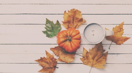 Cup and pumpkin with leafs