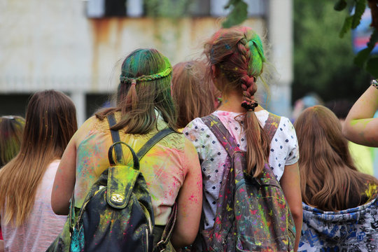 Two young girls painted with dry multicolored paints at the festival Holi festival in Gatchina, Russia.