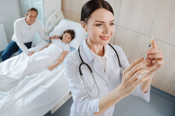 Cheerful positive doctor preparing for an injection