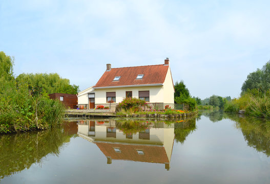 Une  jolie maison se reflétant dans les eaux calmes des marais  de  Saint Omer 