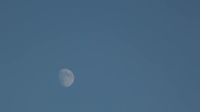 Slow movement of the Moon on the blue sky