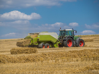 Fototapeta na wymiar Traktor mit Strohpresse, Strohernte