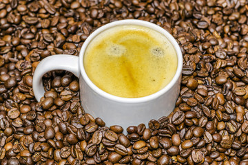 Cup of coffee and beans at backrounds