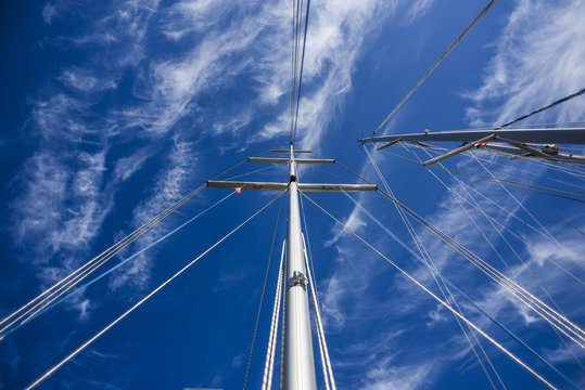 Mast in cloudy sunny day, with sails, summer time.