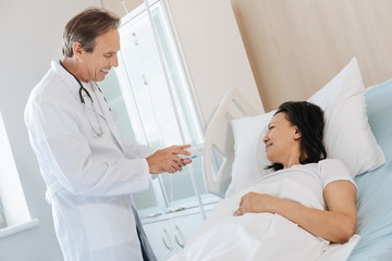 Obraz premium Nice cheerful doctor showing the medicine to his patient