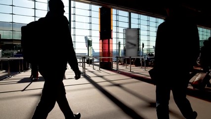 Passengers rushing past empty boarding gates, airport fuss, departed airplane