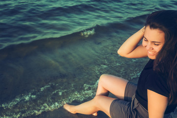 Obraz premium woman sits on the rock and lookin for lake view