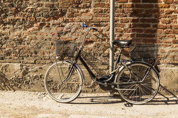 Fototapeta na wymiar Old bicycle parked on a building wall in Ravenna, Italy