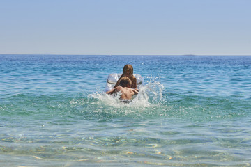 Happy Sister and Brother Children Playing with Inflatable Mattress at Adriatic Blue Sea, Hvar island, Croatia. Concept of happy summer holiday