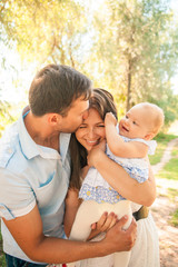 Fototapeta premium Happy young family spending time outdoor on a summer day, picnic in the park.