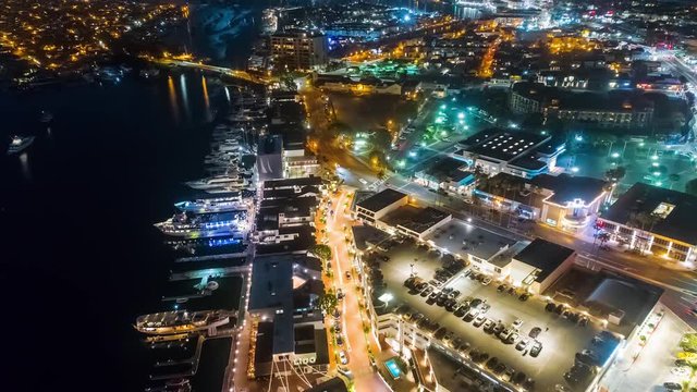 Cinematic urban aerial time lapse in motion or hyper lapse from drone in the evening over a busy street onramp towards harbor restaurants.