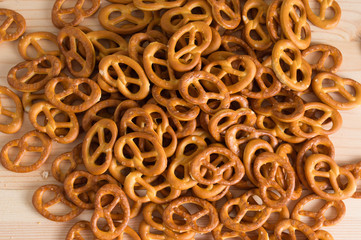 Background texture of salted savory mini pretzels in the traditional looped knot shape. Top view full frame from overhead.