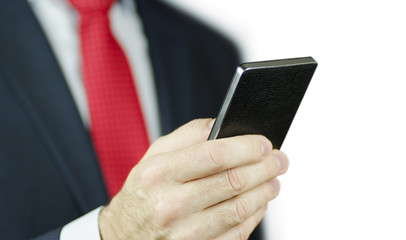 A close-up view of a manager's hand in a suit and with a red tie using a black smartphone, isolated on white background